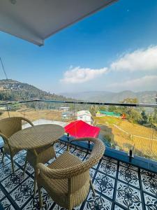 a balcony with a table and chairs and a view at Advaya Stays Luxury 1BHK Villa- The Sunrise Studio in Mukteswar