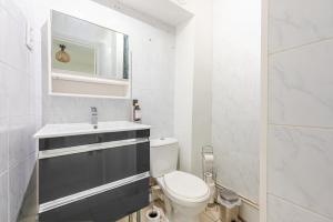 a white bathroom with a toilet and a sink at Urban Oasis, RER D, CDG Aéroport, Parc des Expos in Gonesse