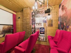 a room with red chairs and a wall with posters at La Parisienne Coquine Love and Plaisir - Love Room in Troyes