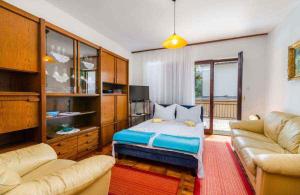 a living room with a bed and a couch at Apartment in Jadranovo 39395 in Jadranovo