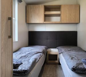 two beds in a small room with a desk and cabinets at Ferienchalet Neunburg vorm Wald Urlaub auf dem Bauernhof in Ebersdorf