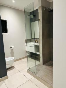 a bathroom with a glass shower and a toilet at Next to Brooklyn Mall Cosy stay in Pretoria +9 photos
