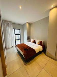 a bedroom with a bed and a large window at Next to Brooklyn Mall Cosy stay in Pretoria