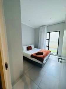 a bedroom with a bed and a large window at Next to Brooklyn Mall Cosy stay in Pretoria