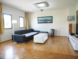 ein Wohnzimmer mit einem Sofa und einem weißen Stuhl in der Unterkunft Künstlerhaus Arthotel in Geislingen