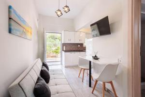 a living room with a couch and a table and a kitchen at Seaview Tranquility - Elegant Escapes by the Shore in Ayía Kiriakí