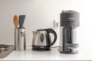 a coffeemaker and a coffee maker on a counter at Appartement Cosy Tout confort Elbeuf in Elbeuf