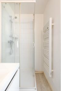 a white bathroom with a shower and a sink at Appartement Cosy Tout confort Elbeuf in Elbeuf +12 photos