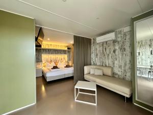 a hotel room with two beds and a couch at Agriturismo Le Tese in Colà di Lazise
