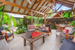 an outdoor patio with chairs and a table at Villa Secret Garden by IHR - Villa privée 2 chambres avec piscine in Rivière Noire