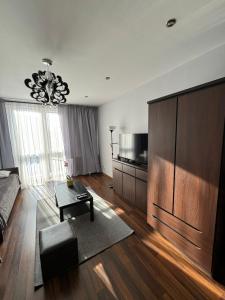 Una sala de estar con un sofá y una lámpara de araña. en Apartament Sandra, en Kielce