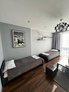 Un dormitorio con dos camas y una lámpara de araña. en Apartament Sandra, en Kielce
