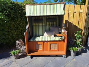 ein Holzstuhl mit einem Baldachin darüber in der Unterkunft Ferienhaus Landliebe in Riepsdorf