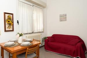a living room with a table and a red chair at Dolce Riviera Marina Centro in Rimini