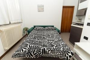 a bedroom with a bed with a black and white comforter at Dolce Riviera Marina Centro in Rimini +9 photos