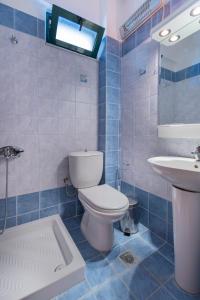 クリオピギにあるAriadni Sea View House by RentalsPro - Kryopigi Halkidikiの青いタイル張りのバスルーム(トイレ、シンク付)