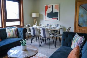 a dining room with a table and a blue couch at Rosehearty house - 3 bedroom in Rosehearty