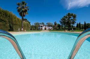 a large swimming pool with a house in the background at Pumperhouse Arles Camargue in Saint-Gilles