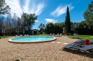 a swimming pool with lounge chairs around it at Pumperhouse Arles Camargue in Saint-Gilles