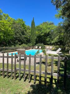 a wooden fence in front of a swimming pool at La bergerie in Grignan