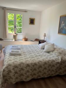 a bedroom with a large bed with two pillows on it at La bergerie in Grignan