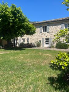a stone house with a tree in the yard at La bergerie in Grignan
