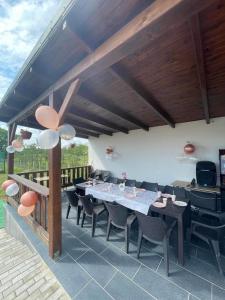 a dining area with a table and chairs on a patio at Liget Vendégház in Bélatanya