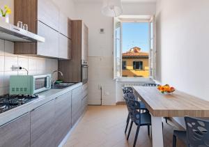a kitchen with a table with chairs and a window at -Cavour 8- 3 rooms with views - near the Tower in Pisa
