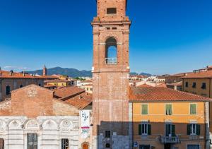 a tall clock tower in a city at -Cavour 8- 3 rooms with views - near the Tower in Pisa