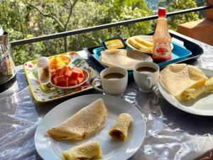 a table with plates of food and cups of coffee at Helly mount inn in Ella