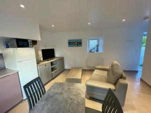 Una cocina y una sala de estar con un sofá y una mesa. en Gîte de penhaudan 3, en Pont-Scorff