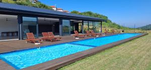 a swimming pool with chairs and a house at Ocean Club Zimbali Lakes D16 in Ballito