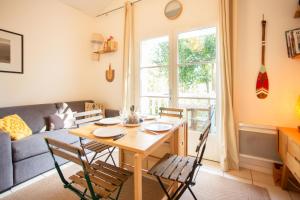 a living room with a table and chairs and a couch at Appartement le Capitaine pour 4 personnes in Cap-Ferret