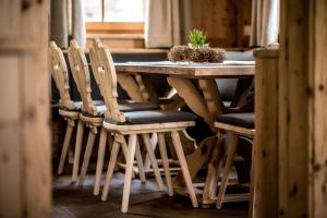 a wooden table with chairs and a potted plant on it at Mountain Chalet Pia in La Valle