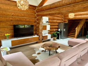 a living room with a couch and a tv at Chalet Matthe Lomnica in Veľká Lomnica