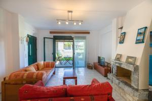 クリオピギにあるAriadni Sea View House by RentalsPro - Kryopigi Halkidikiのリビングルーム(赤いソファ、暖炉付) +45枚の写真