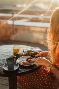 a woman sitting at a table with a plate of food at Hotel Indigo Bordeaux Centre Chartrons by IHG in Bordeaux