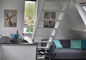 a kitchen with a white spiral staircase next to a couch at Appartement Klein Waldeck in Velp +55 photos