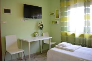 a room with a desk and a table and a tv at Villa Elena in Montesilvano