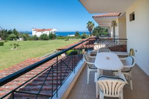 クリオピギにあるAriadni Sea View House by RentalsPro - Kryopigi Halkidikiのテーブルと椅子と海のあるバルコニー