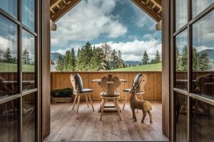 een uitzicht vanaf de veranda van een huis met ramen bij Mountain Chalet Pia in La Valle