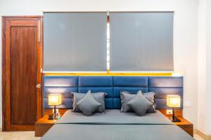 a bed with a blue headboard and two lamps at Housr 1RK & 1BHK Apartment Sector 28 Near Galleria Market in Gurgaon