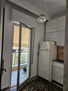 a kitchen with a refrigerator and a large window at Rapsani in Karianí +3 photos