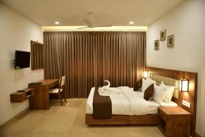 a bedroom with a large bed with a desk and a desk at Golden Star in Kollam
