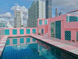 un edificio rosa con piscina in una città di P Villa Lamoon Thonglor a Bangkok