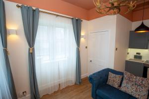 a living room with a blue couch and a window at West Lodge, High Street in Aberlour