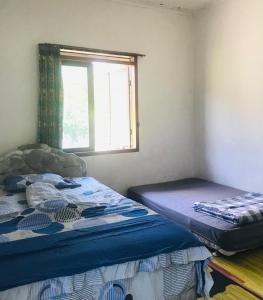 ein Schlafzimmer mit zwei Betten und einem Fenster in der Unterkunft Villa Rian Argapuri Resort in Gambung