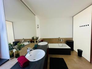 a bathroom with two sinks and a bath tub at LakeSide - exklusives Architektenhaus C5 mit Seesicht auf der Höri in Öhningen +44 photos