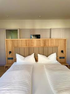 two beds with white pillows in a room at Gartenvilla in Marktheidenfeld +1 photo