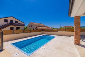 a swimming pool in the backyard of a house at Holiday house DIVNA in Pinezici
